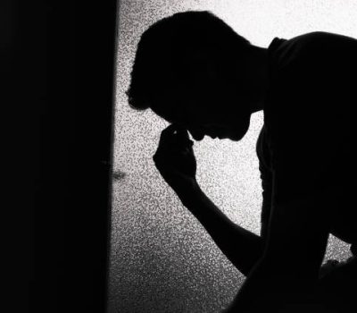 Young sad man sitting in the dark room. Young sad man sitting in the dark room.